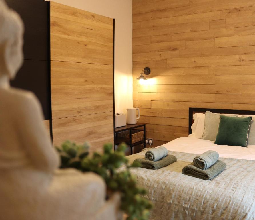 伊斯特布恩Emerald nest Eastbourne的一间卧室配有一张床,上面有两条毛巾