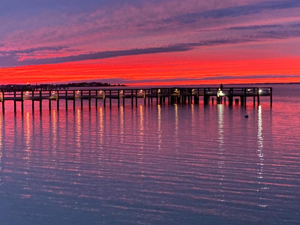 纳瓦拉Romantic Island condo for 2 - Sunset Harbor 1-205 - Navarre Beach的水面上的码头,有红色的日落