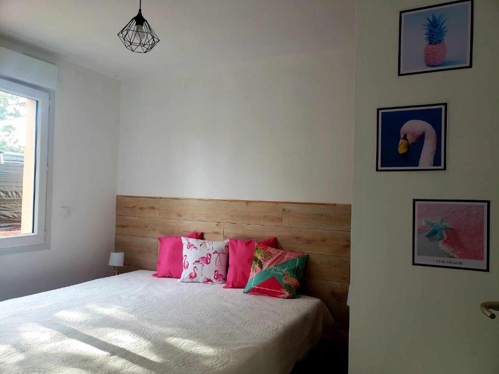 Ginasservisles gites du parc animalier de ginasservis的一间卧室配有带粉红色枕头的床和窗户。