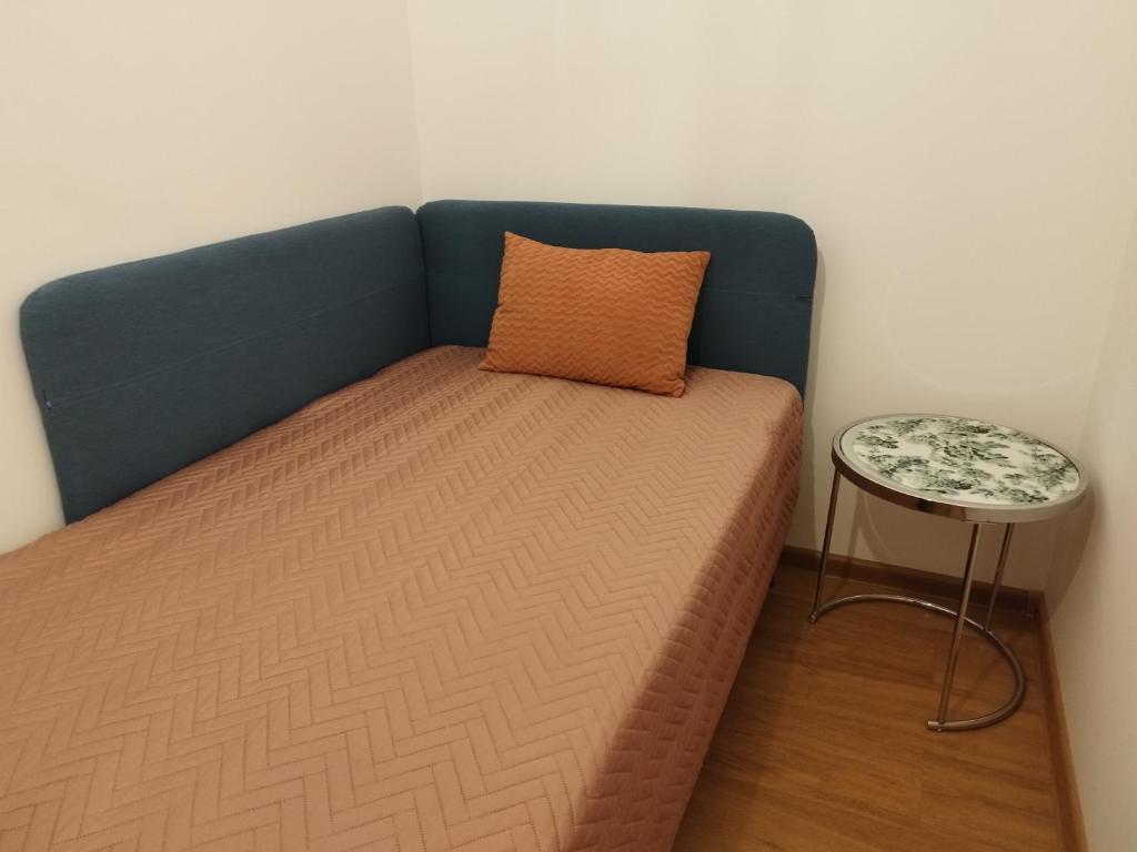 华沙Villa Natali Warszawa的一张带枕头和边桌的床