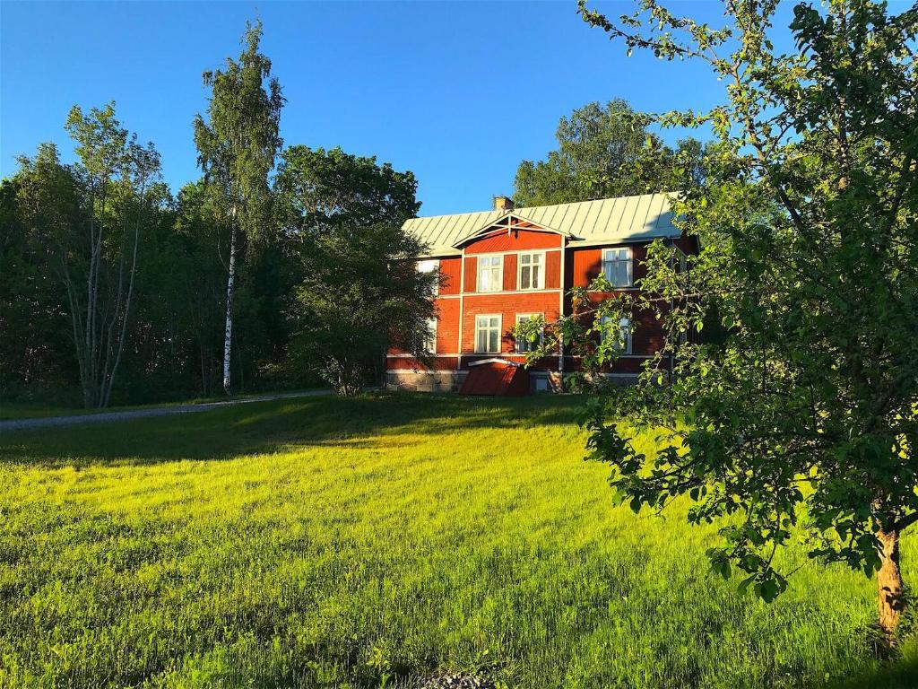 MalmköpingBig spacious countryhouse typical Swedish red wooden house (1h from Stockholm)的绿色田野中间的红色房子