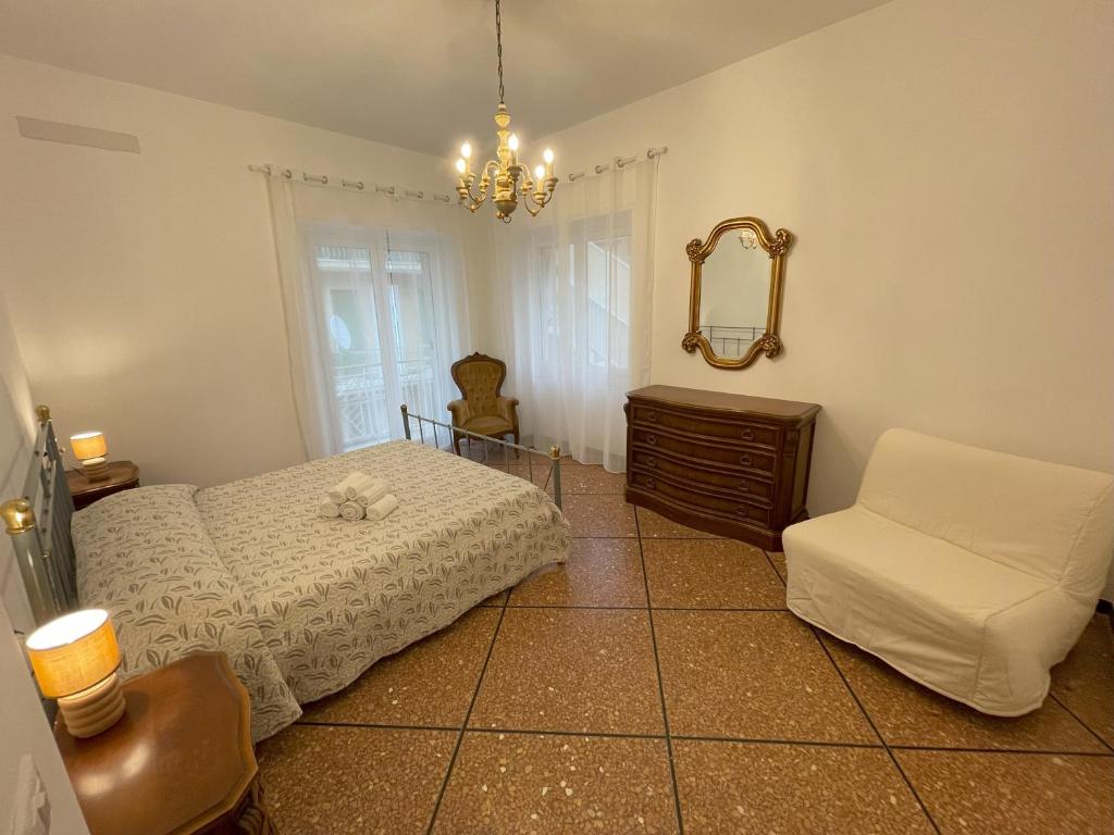 阿拉西奥Airaldi8 -Ex La Reggia- Trilocali in centro a 50 m dal mare的一间卧室配有一张床、一把椅子和镜子