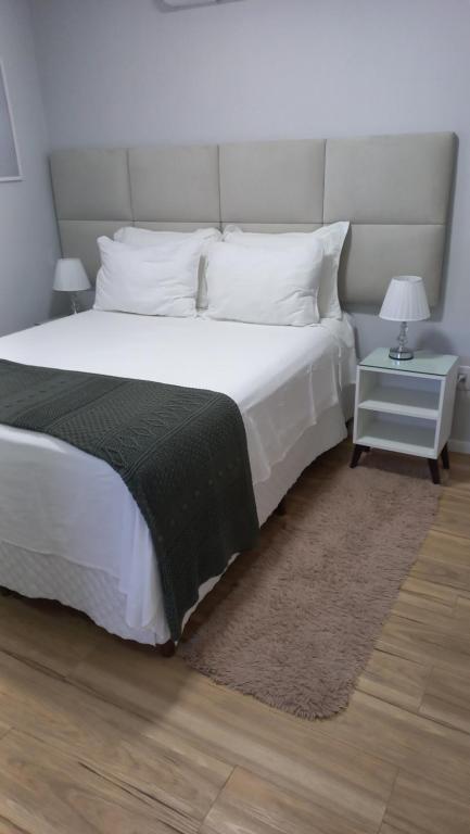 安格拉杜斯雷斯Studio Praia do Jardim 1 305B的卧室配有一张带黑色毯子的大型白色床。