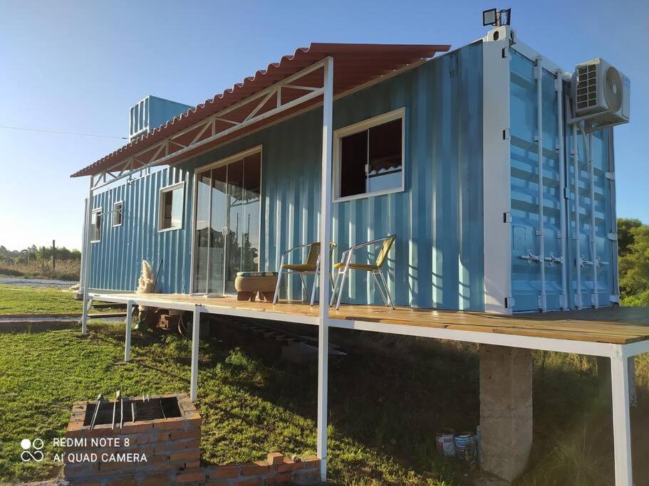 巴热Casa Container Azul.的蓝色的小房子,坐在木甲板上