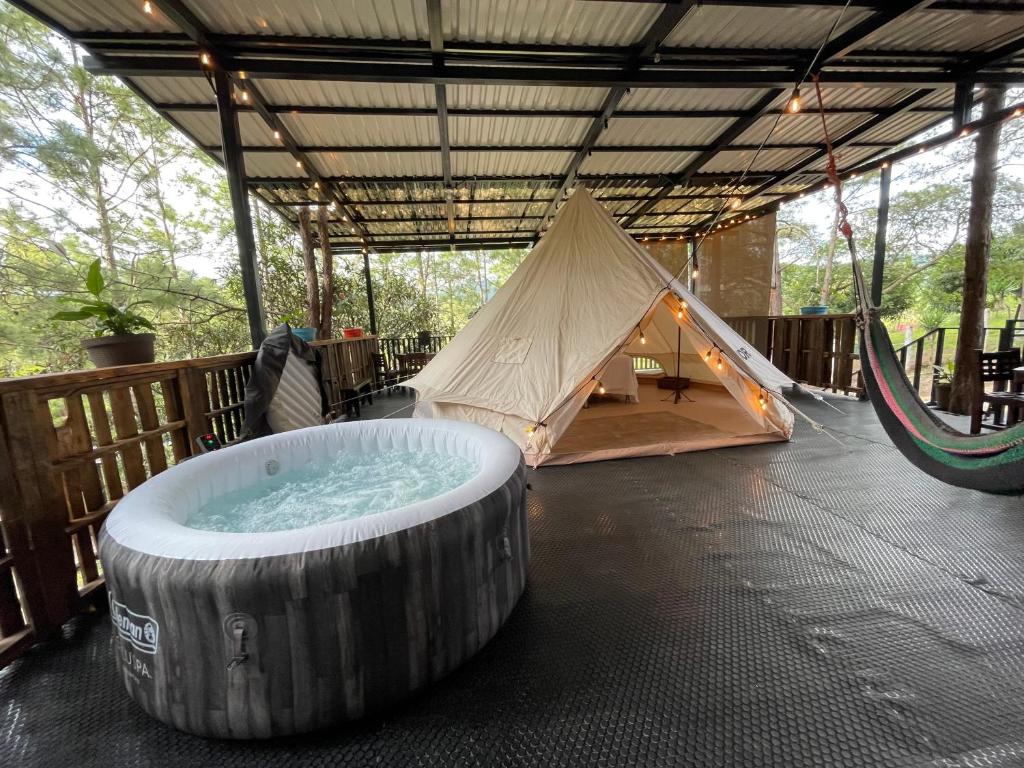 安赫莱斯镇Glamping Anturios的帐篷以及带吊床的浴缸。