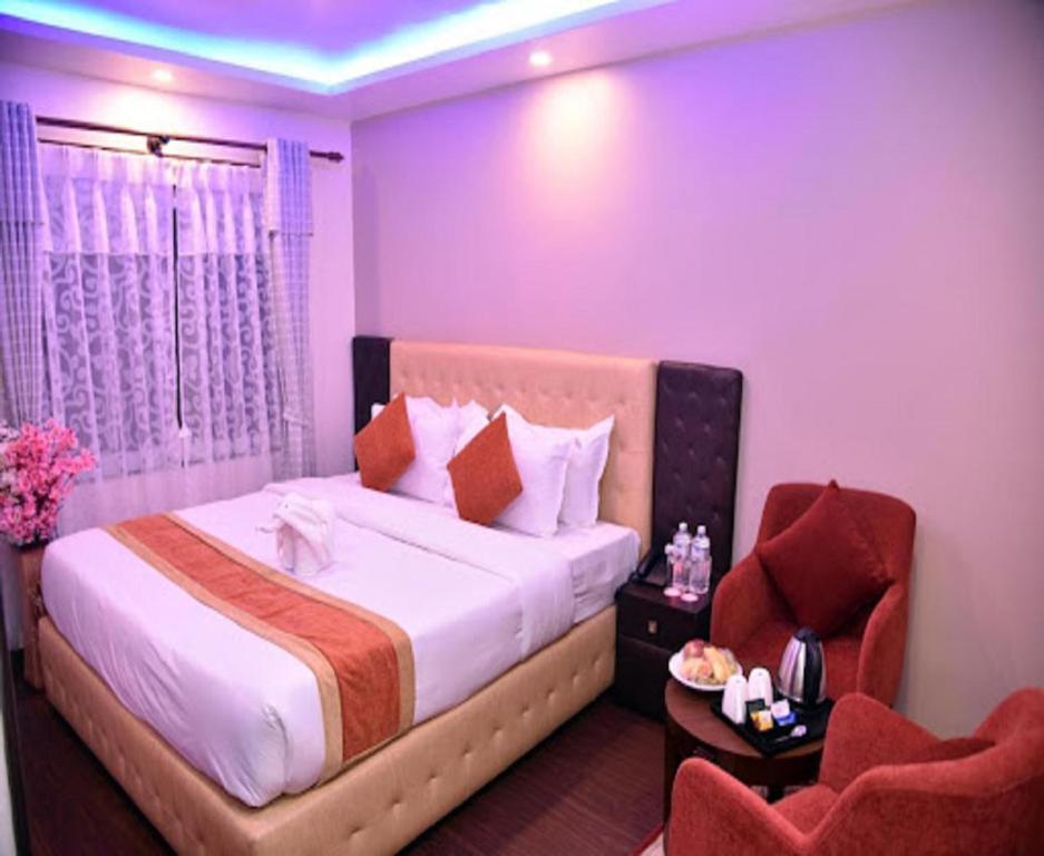 新德里Hotel MARISA GRAND Near Delhi Airport BY Aero Home的一间卧室配有一张大床和一把椅子
