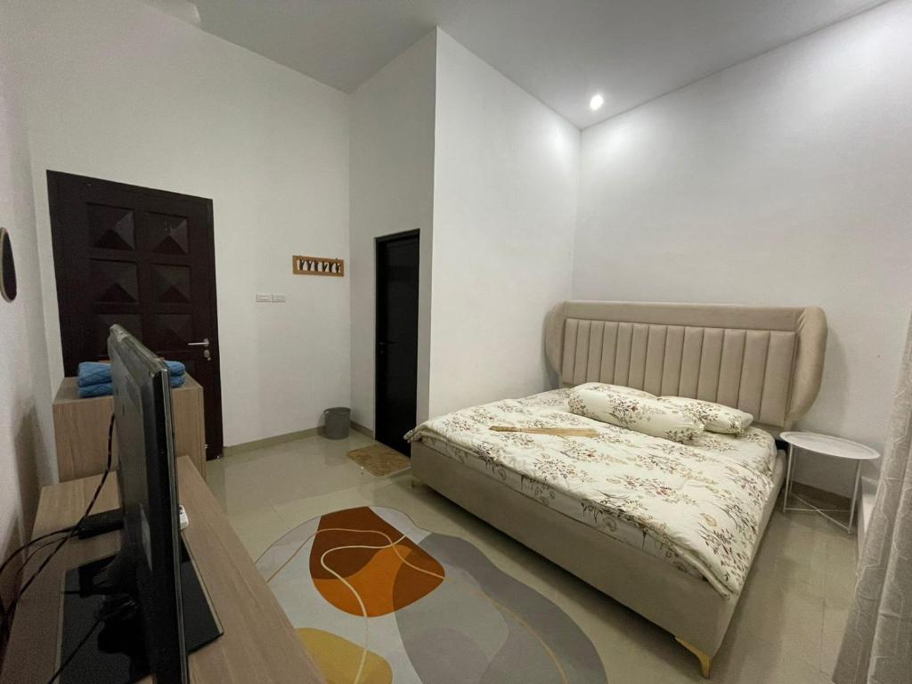 Kedatond’Viella Lampung的一间卧室配有一张床和一台平面电视