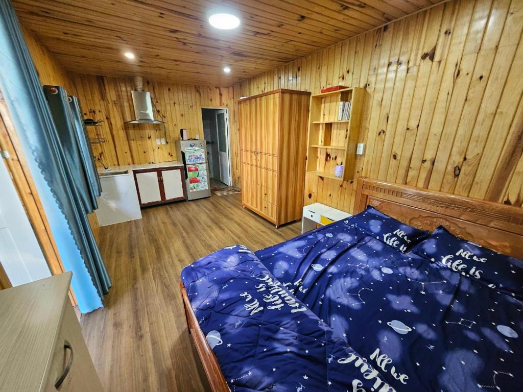 Trai MatCherry Trại mát homestay的卧室配有一张床铺,位于带木墙的房间内