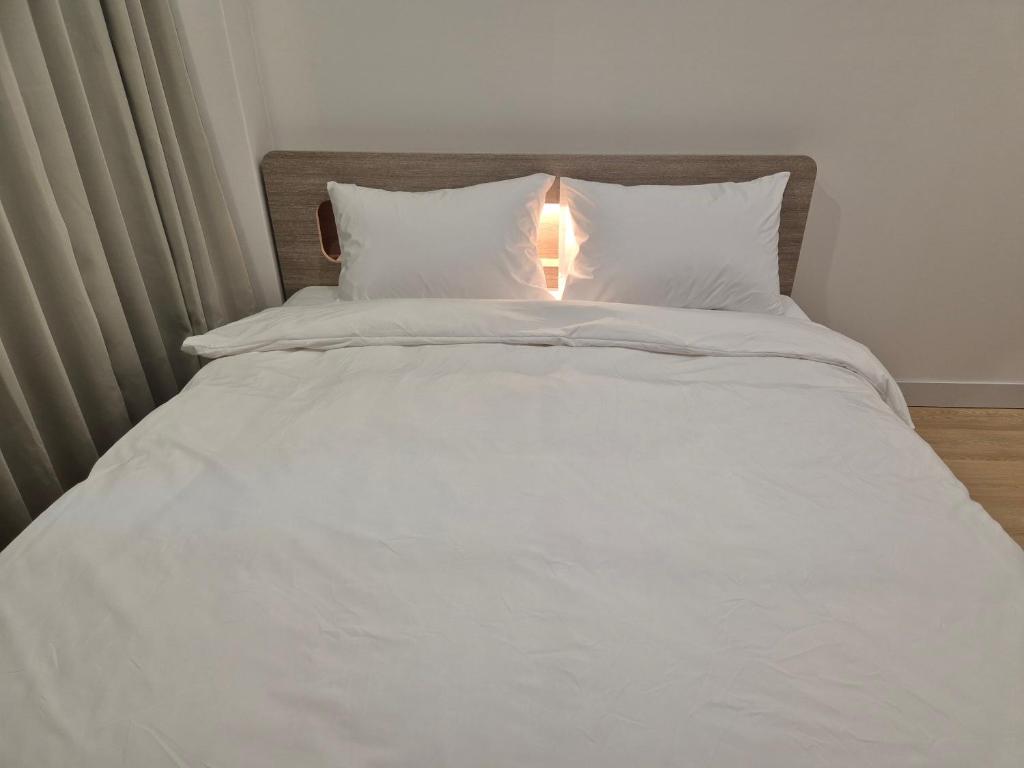 釜山光张酒店的一张白色的床,上面有灯