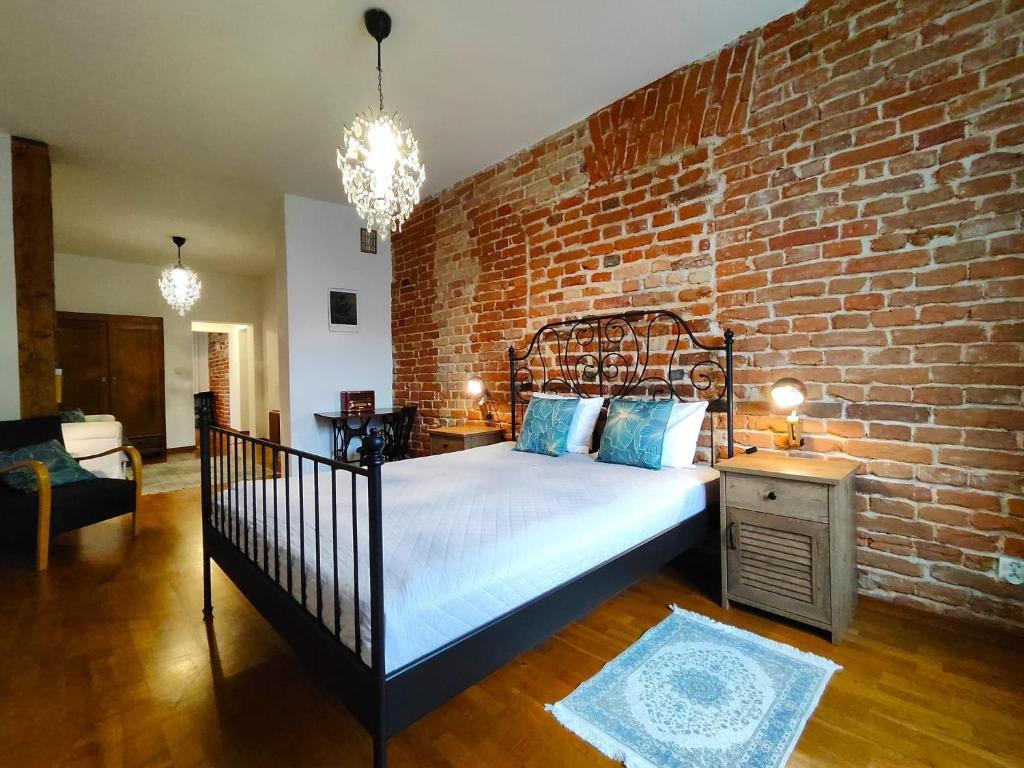 萨诺克Apartament Skorpion Centrum的一间卧室配有一张砖墙床