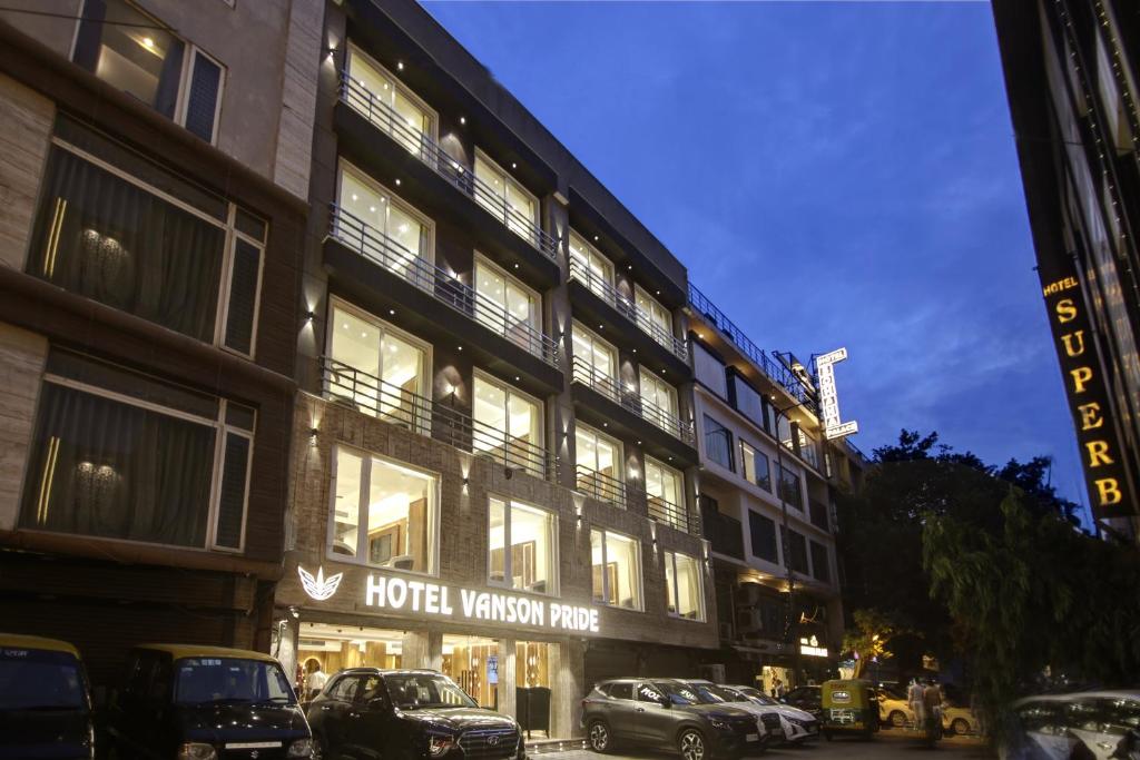 新德里The Vanson Pride Delhi的酒店大楼前面设有停车场