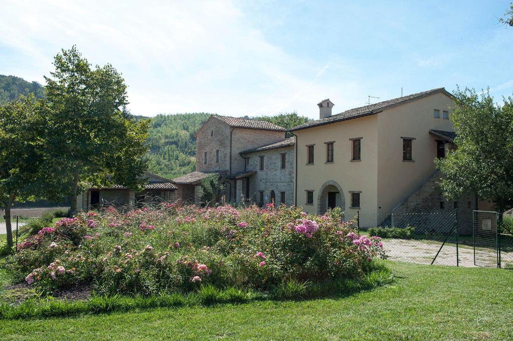 FermignanoAgriturismo Verziere的一座花园,在一座建筑前种有鲜花