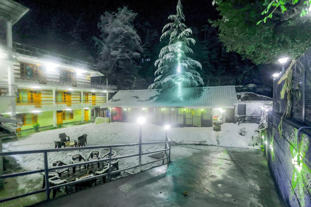 马拉里Luvya Retreats Hotel的雪中有一棵圣诞树的建筑