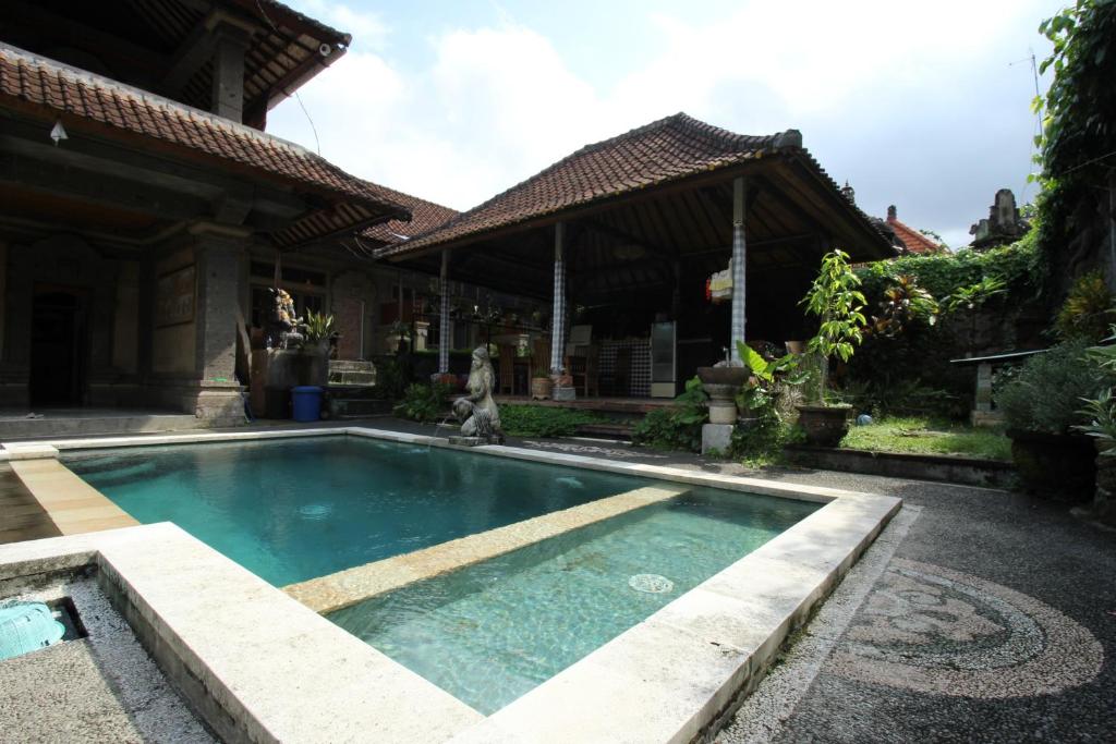 乌布Belvilla 93916 Budi House Near Ubud Palace的房屋前的游泳池