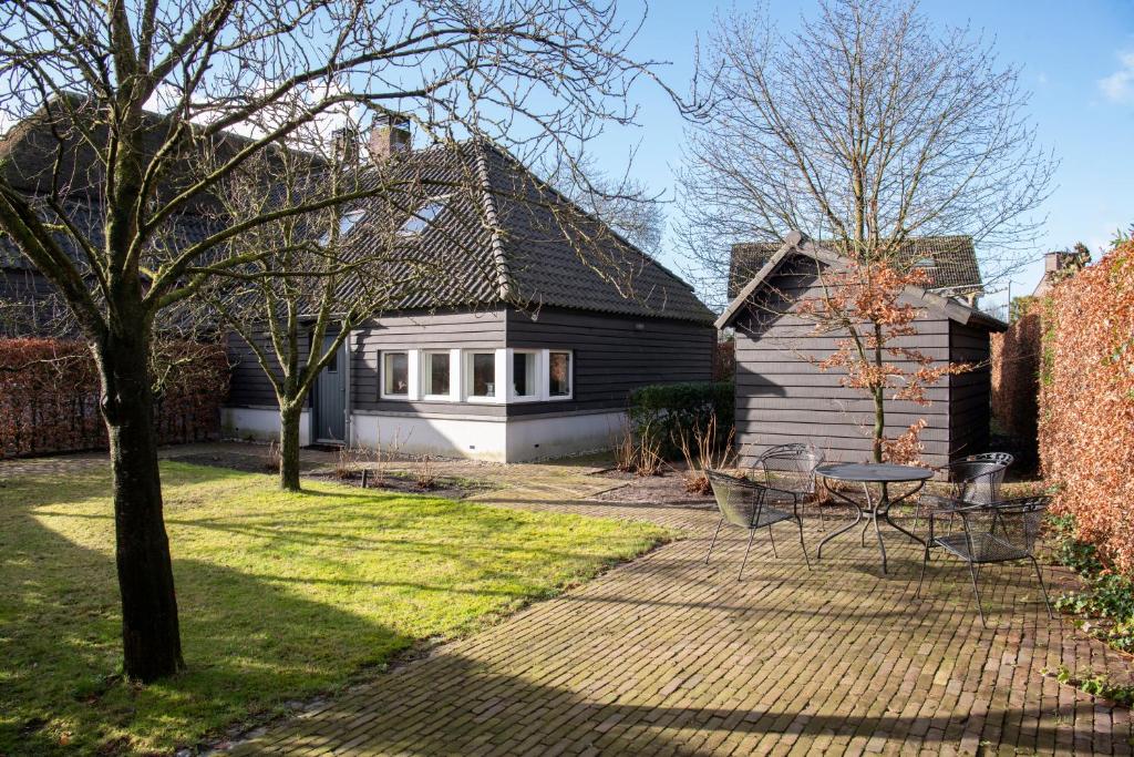 Sint-OedenrodeB&B aan het Dijksteegje的院子内带桌椅的房子