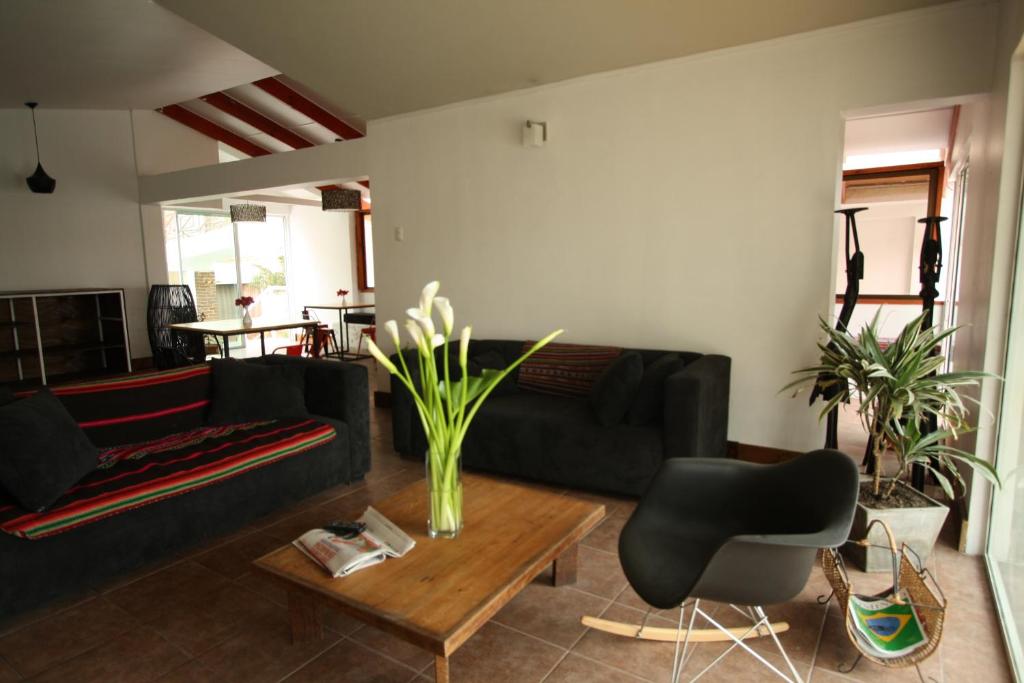 阿里卡Hotel Avenida en Arica的客厅配有黑色沙发和桌子