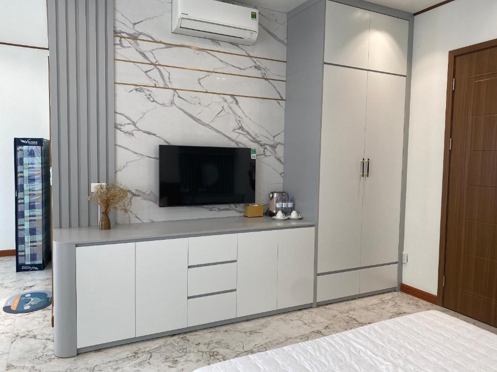 Hòa BìnhMia homestay - Vinhomes Ocean Park 2 - 3的一间带电视和白色橱柜的客厅
