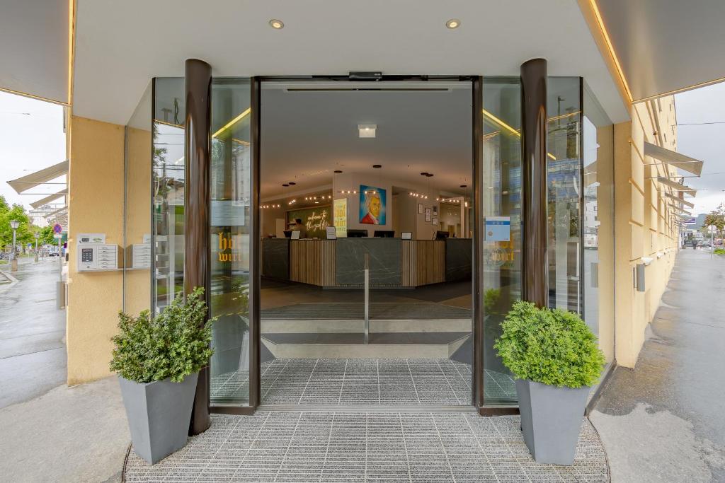 萨尔茨堡萨尔茨堡霍夫维特老城区酒店的拥有两株盆栽植物的购物中心的入口