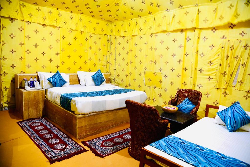 斋沙默尔Serendipity desert Camp in Thar Desert的一间设有两张床和一张桌子及椅子的房间