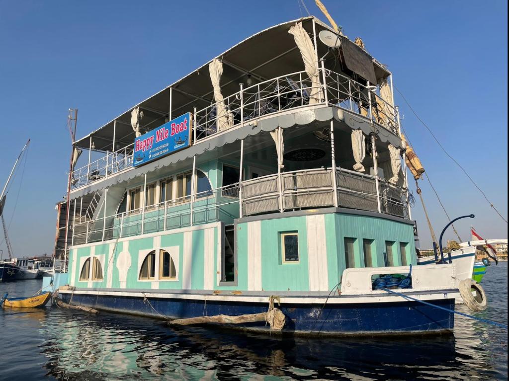 卢克索Floating Hotel- Happy Nile Boat的一艘渡轮停靠在水中