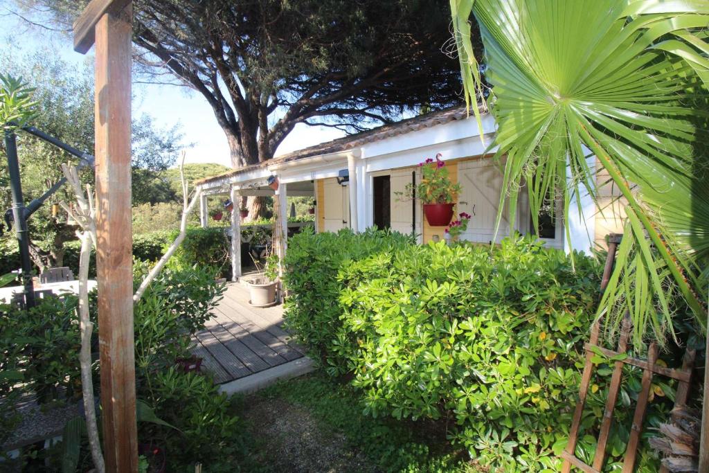 加桑Gasgol11 - Golfe de St-Tropez - Chalet dans coin de verdure的白色的房子,有门廊和灌木丛