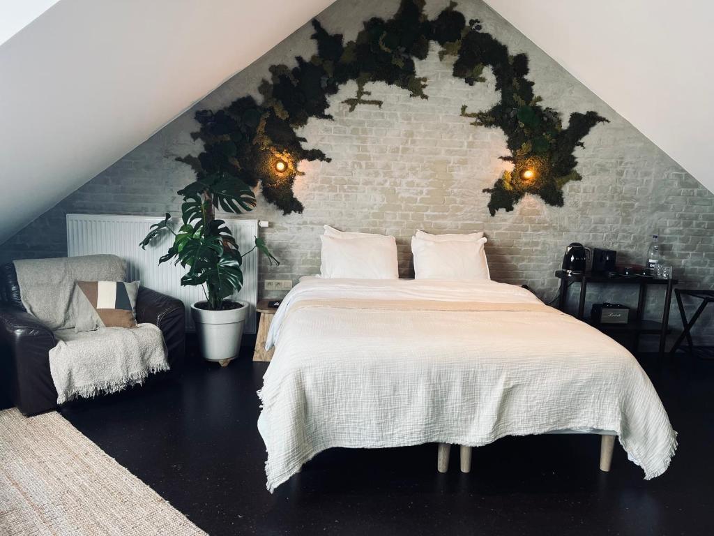杜柏La Grainerie的一间卧室设有一张大床和砖墙
