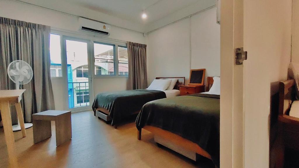 曼谷Whole 3-storey house right in the local community.的酒店客房设有两张床和窗户。