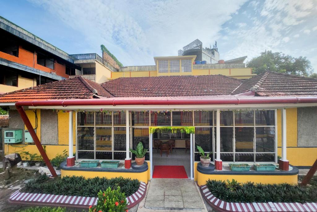 丹戎槟榔RedDoorz Syariah Near Pelabuhan Sri Bintan Pura Tanjungpinang的黄色的房子,有种有植物的门廊