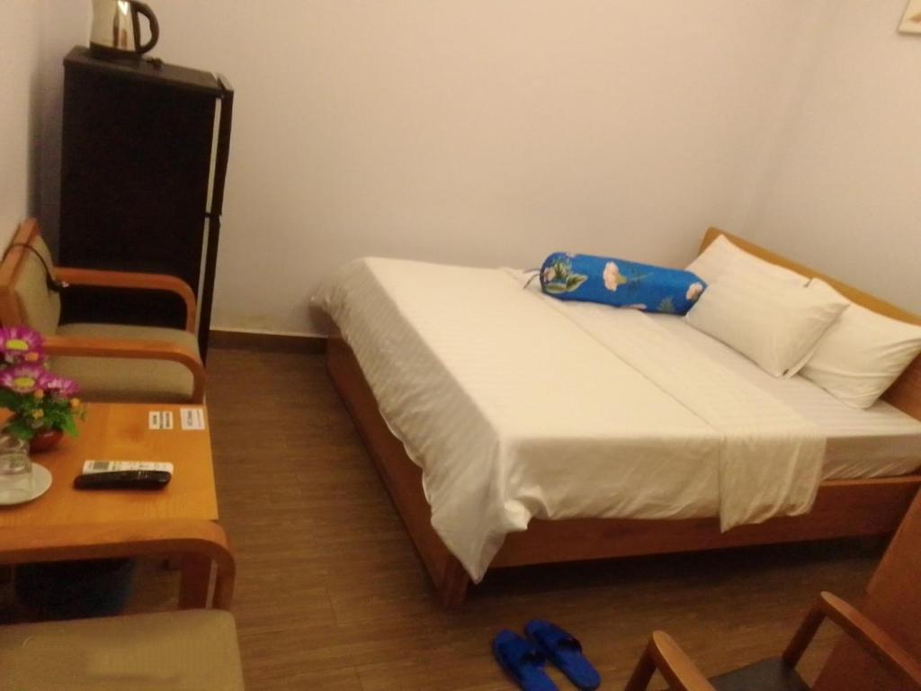 胡志明市102 House的卧室配有1张床、1张桌子和1把椅子