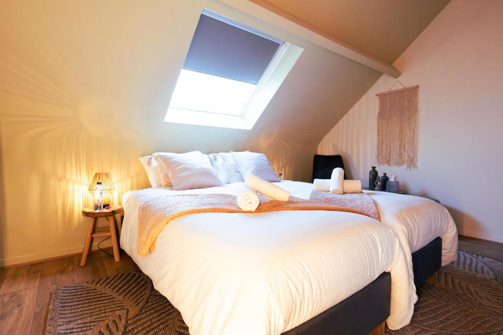 蒙斯Lets Relax - Coté Nature的卧室配有一张白色大床和天窗