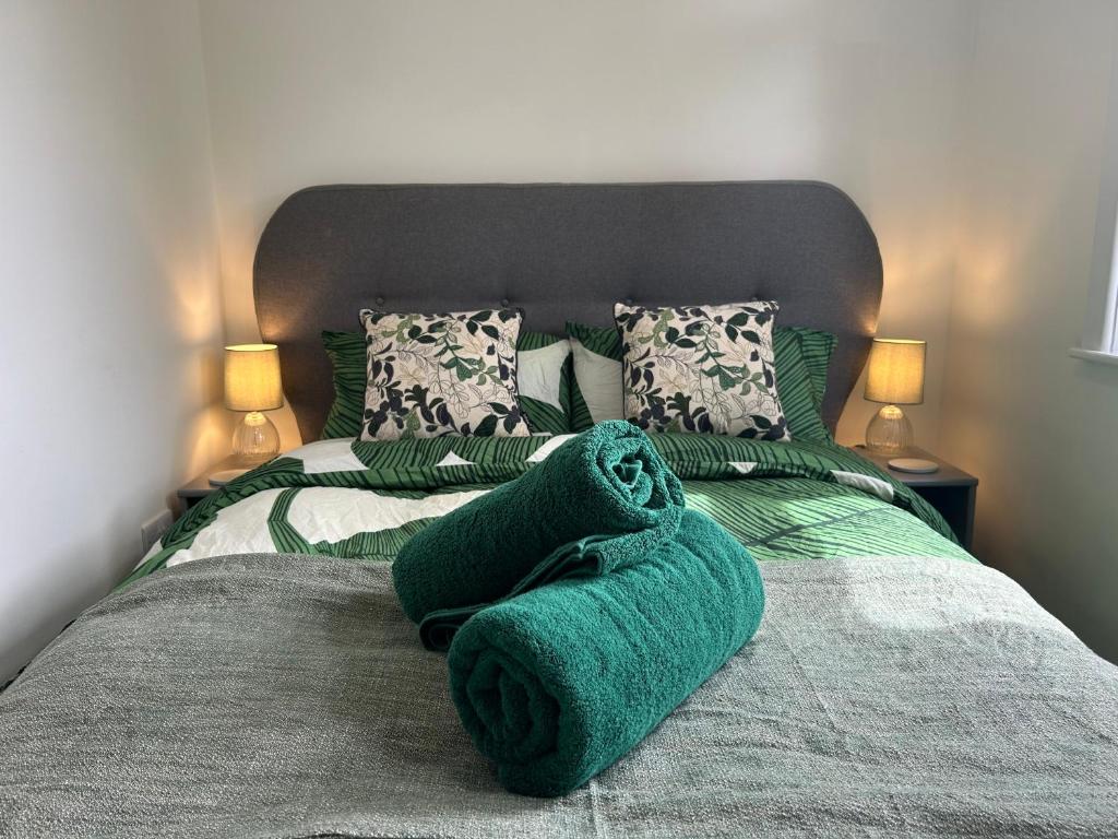 南安普敦Urban Escape Entire Apartment Near Uni and Hospital的一张带绿毛巾的床和两盏灯