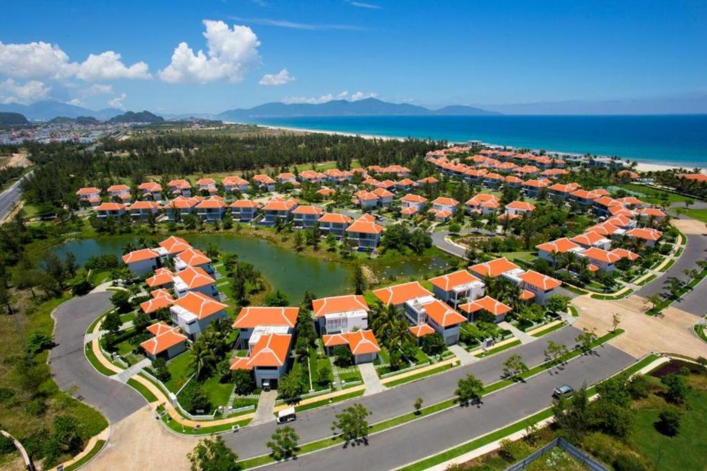 岘港Ocean Beach Resort Da Nang的享有带橙色屋顶的度假村的空中景致