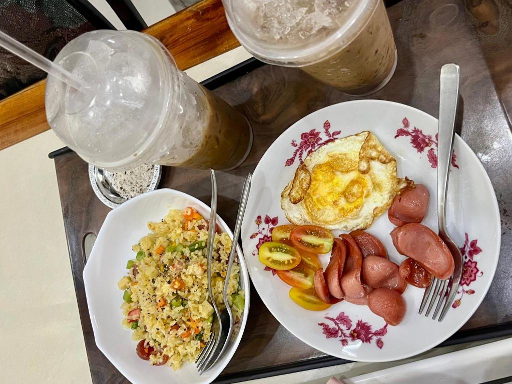 朱笃Cherry Homestay - Hoàng Đế motel的托盘,托盘上放有鸡蛋香肠和米饭的两盘食物