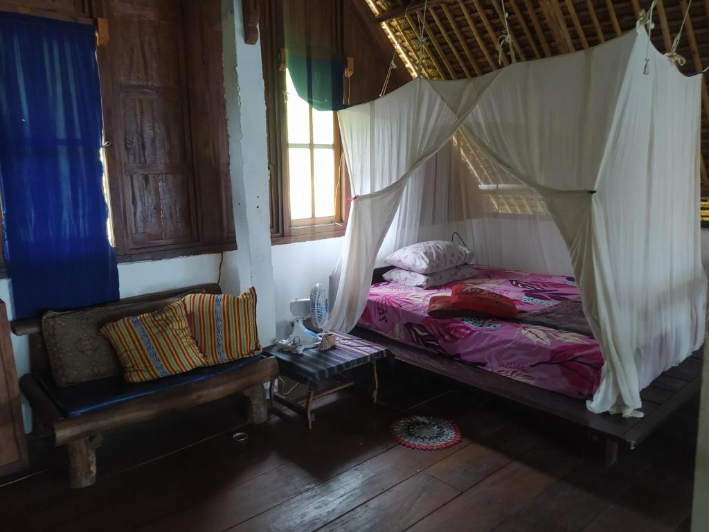 HitokalakVilla Watumita Sikka的一间卧室配有一张带蚊帐的床