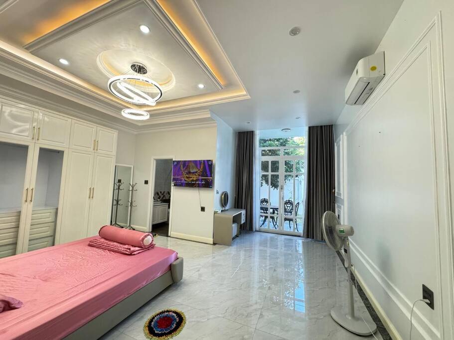 Xóm VàngVilla for rent in Tra Vinh City的卧室配有粉红色的床。