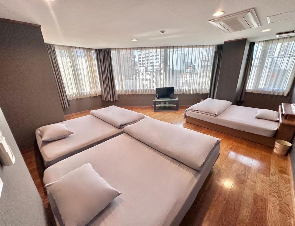 宇都宫Maria Hotel 宇都宮的客房设有两张床、一张沙发和窗户。