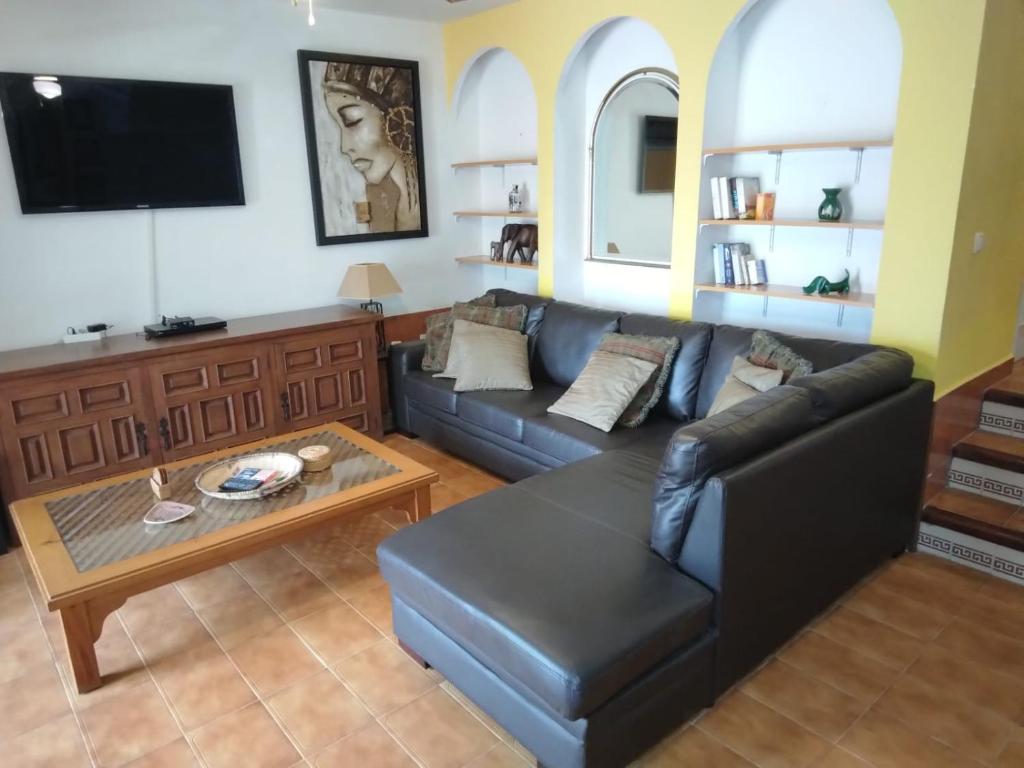 圣路易斯·德·萨比尼尔Lamedos的客厅配有黑色真皮沙发和桌子