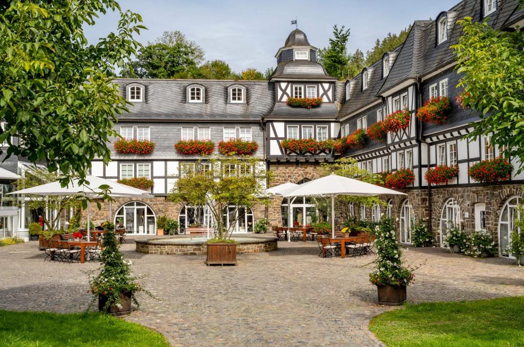 施马伦贝格戴曼酒店的庭院内带桌子和遮阳伞的建筑