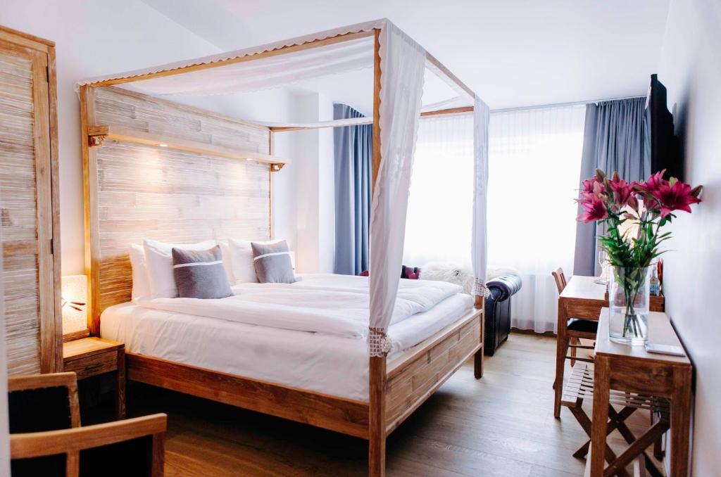雷克雅未克艾加古斯米登酒店的一间卧室配有天蓬床和鲜花桌