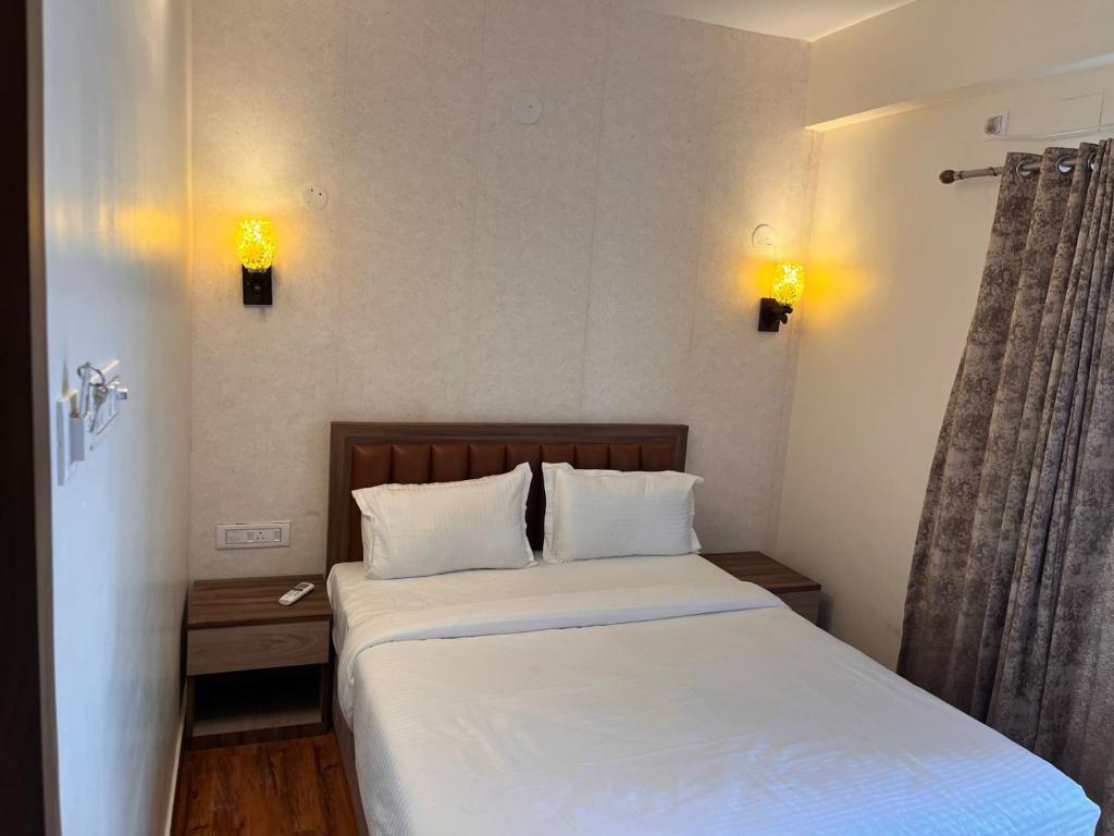 加尔各答The Lake Palm Hotel的一间卧室配有带白色床单和枕头的床。