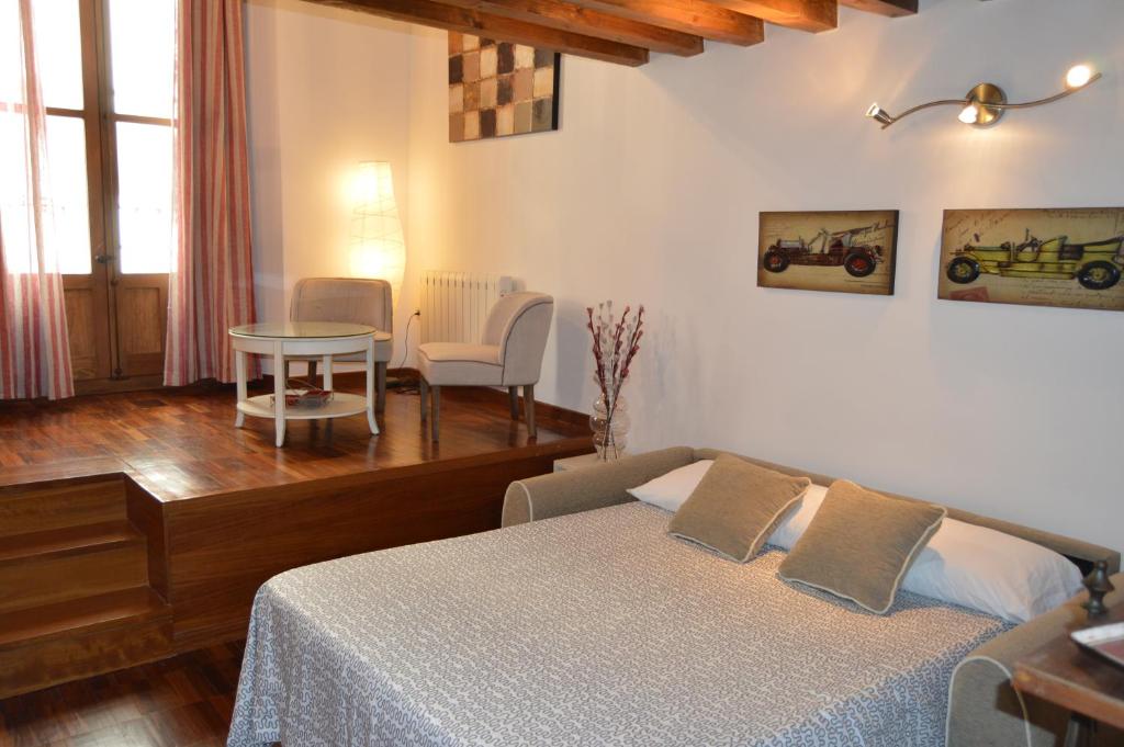 托莱多Apartamentos Nuncio Viejo的卧室配有一张床和一张桌子及椅子