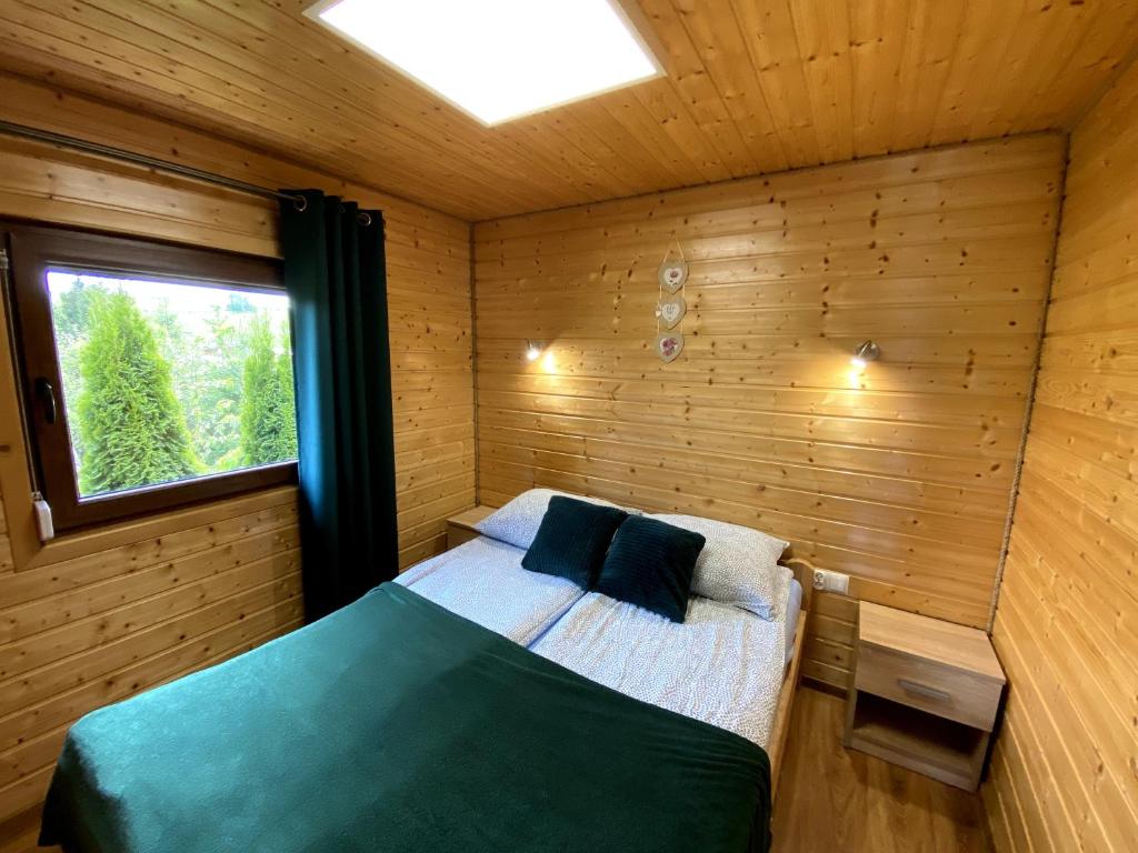 布科维茨Bieszczadzkie domki z widokiem 793-903-243的木制客房内的一间卧室,配有一张床