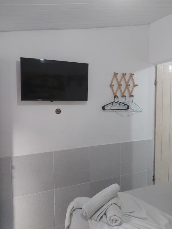 嘎林海斯港Pousada Porto Marola的墙上设有1间带平面电视的浴室
