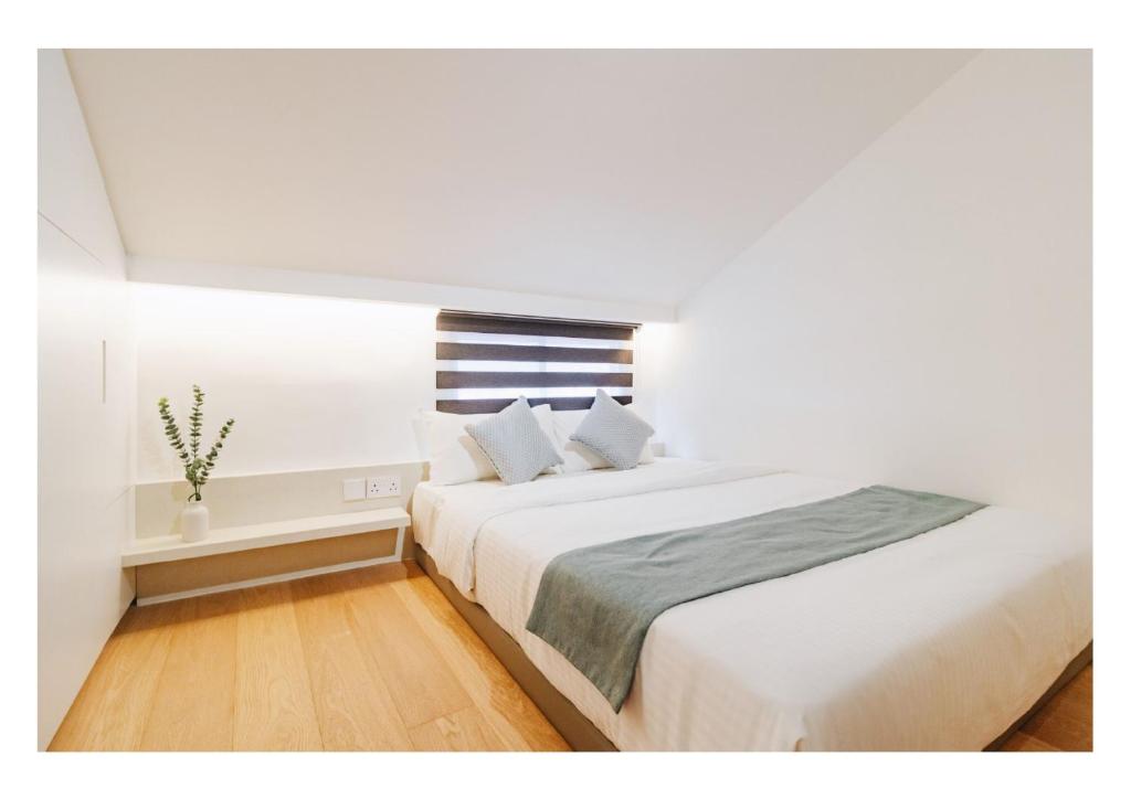 新加坡Serenity Suite的白色的卧室设有一张大床和一个窗户