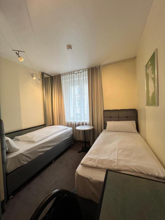 杜塞尔多夫Hotel Monopol City Centre的酒店客房设有两张床和窗户。