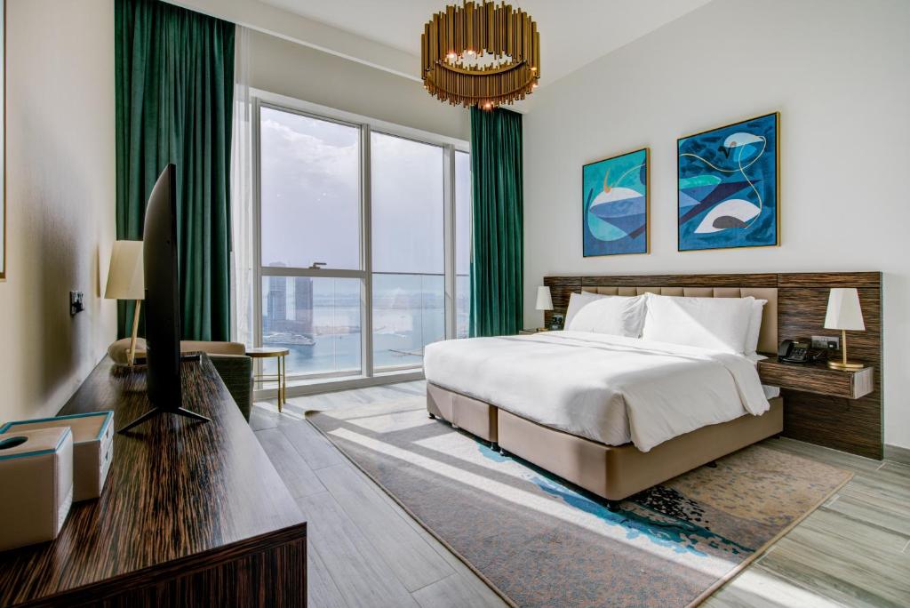 迪拜Avani Plus Palm View Dubai Suites的一间卧室设有一张床和一个大窗户