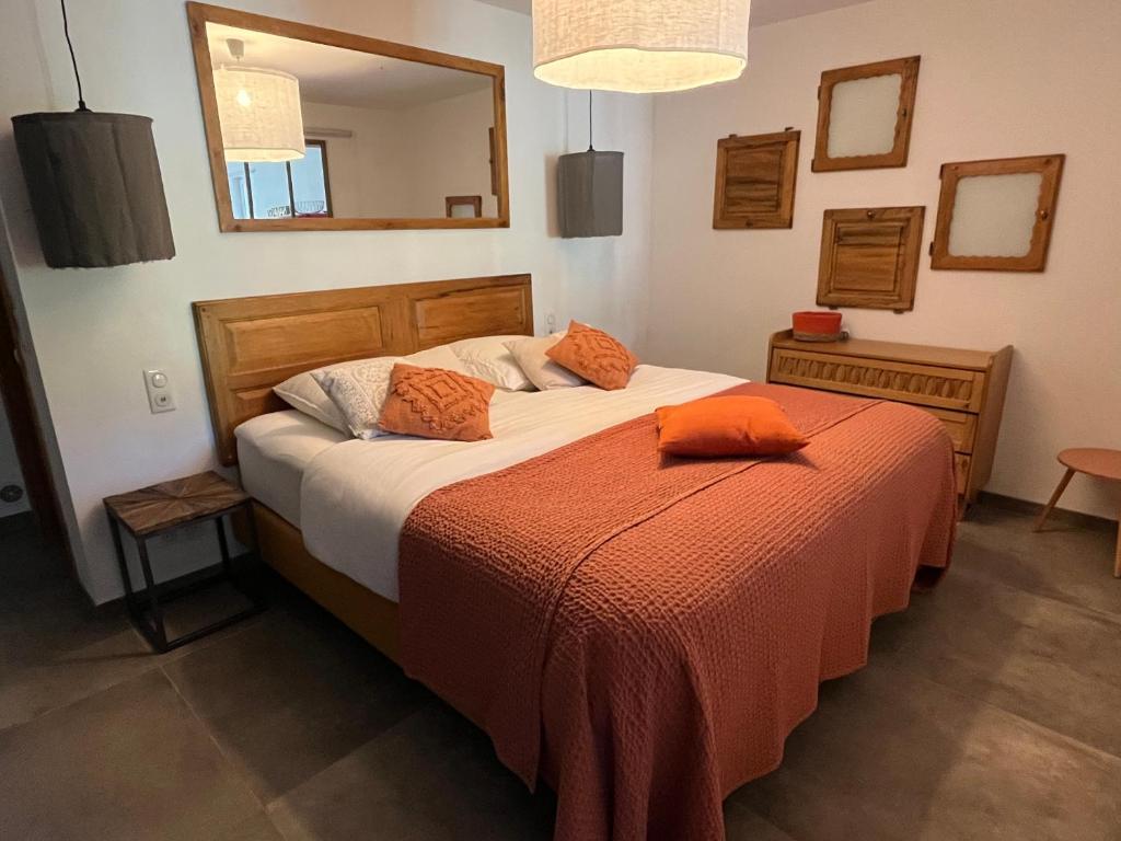 罗宾鲁伯龙Hestia的一间卧室配有一张带橙色毯子和镜子的床