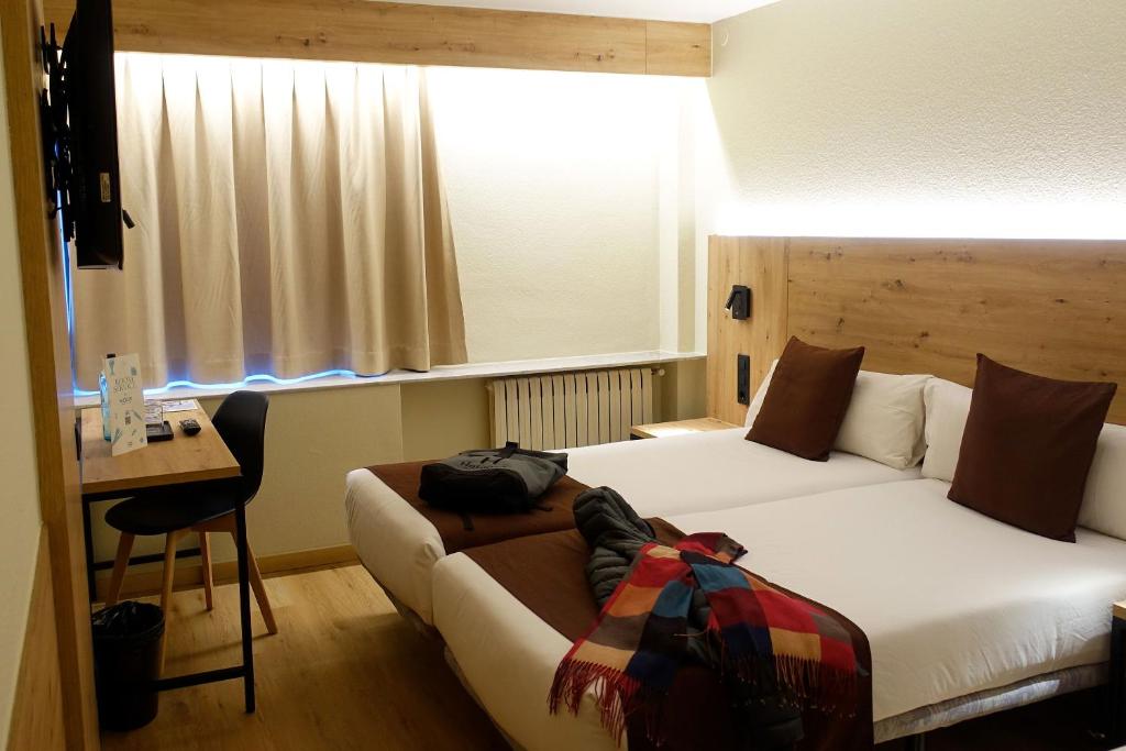 安道尔城Comtes d’Urgell的酒店客房配有两张床和一张书桌