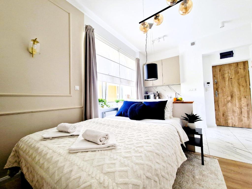 华沙J&W Apartments Grójecka Glam Flat的一间卧室配有一张大床和毛巾