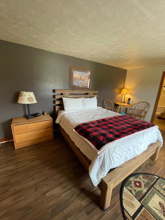 StrattonSpillover Motel and Inn的卧室配有一张床和一张桌子及椅子